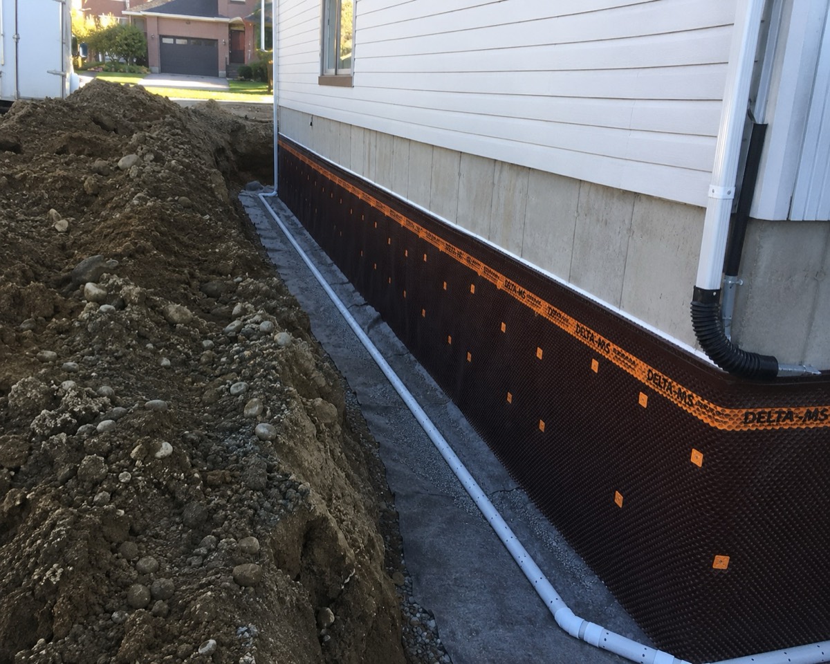 Membrane d'imperméabilisation Delta-MS et drain français installés le long d'une fondation, tranchée ouverte